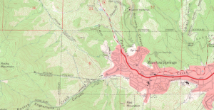 On this too map, the city appears in dark red, with an even darker red main road. The surrounding area is in various shades of green.