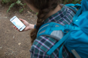 female hiker using Gaia GPS on Android phone to navigate the trail.