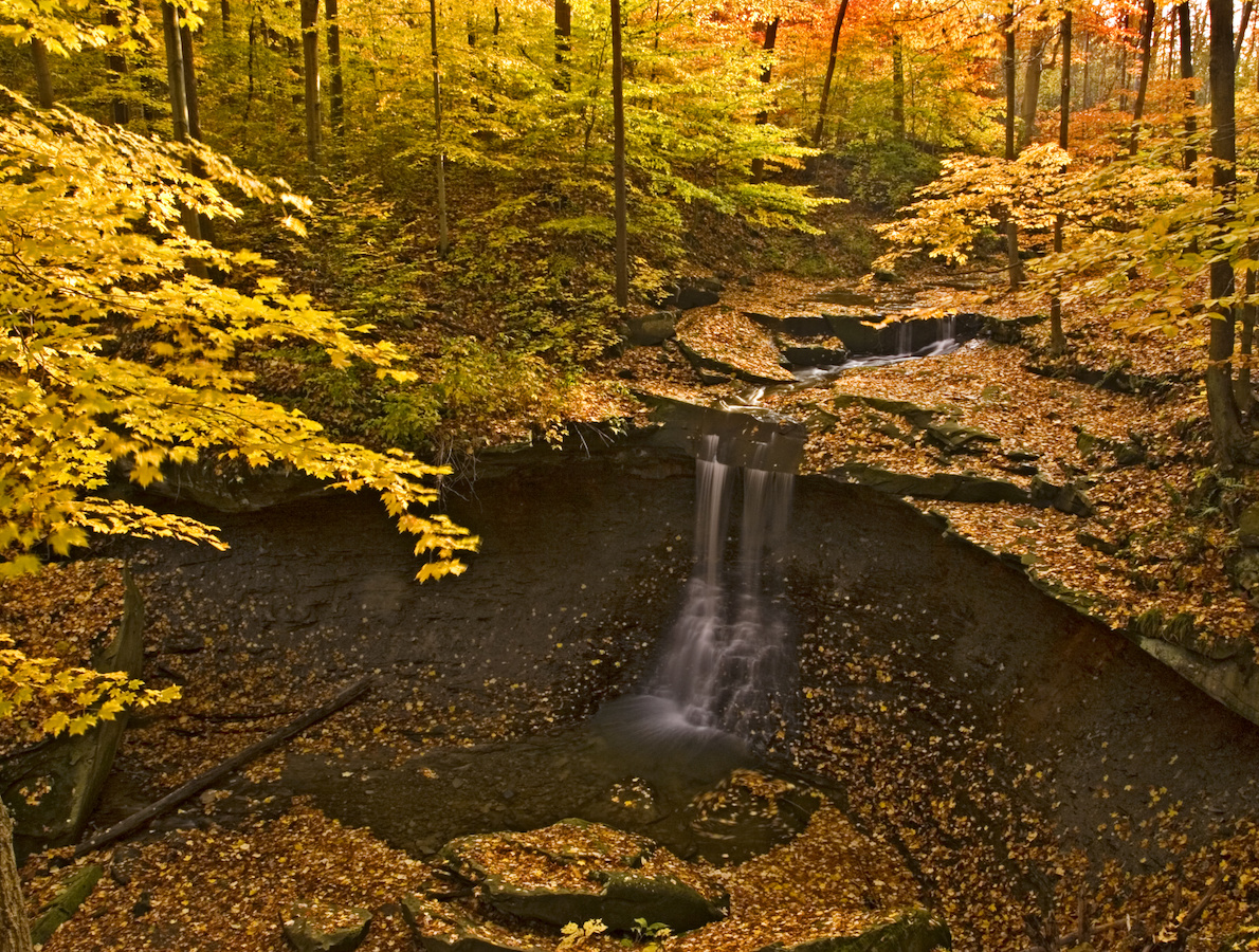 Waterfall in Cuyahoga National Park covered in fall leaves.