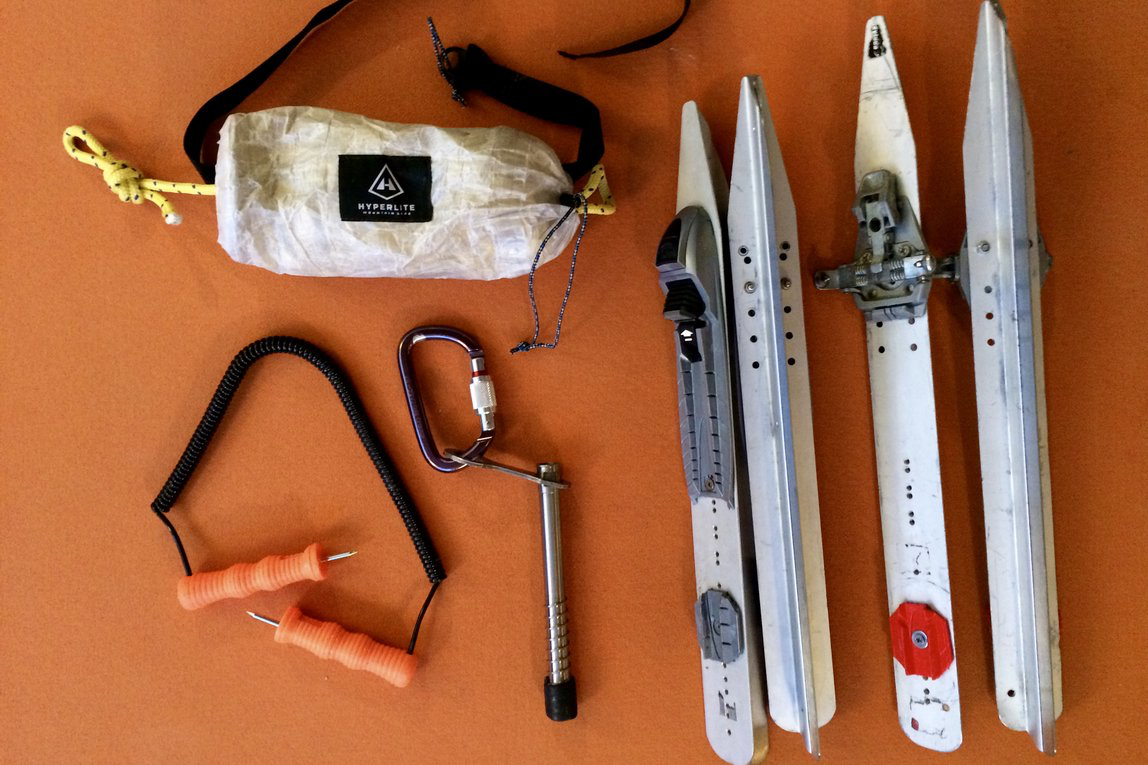 Rescue gear for iceskating in the wild: a throw bag, an ice anchor.  Also, two pairs of nordic skates with ski bindings mounted on them . 