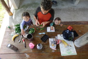 Scott Jurek and his two young children prepare a soba noodle dish on a picnic table at an outdoor pavilion.