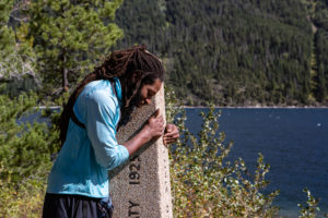 Akuna hugs a post signifying the end of the PCT.