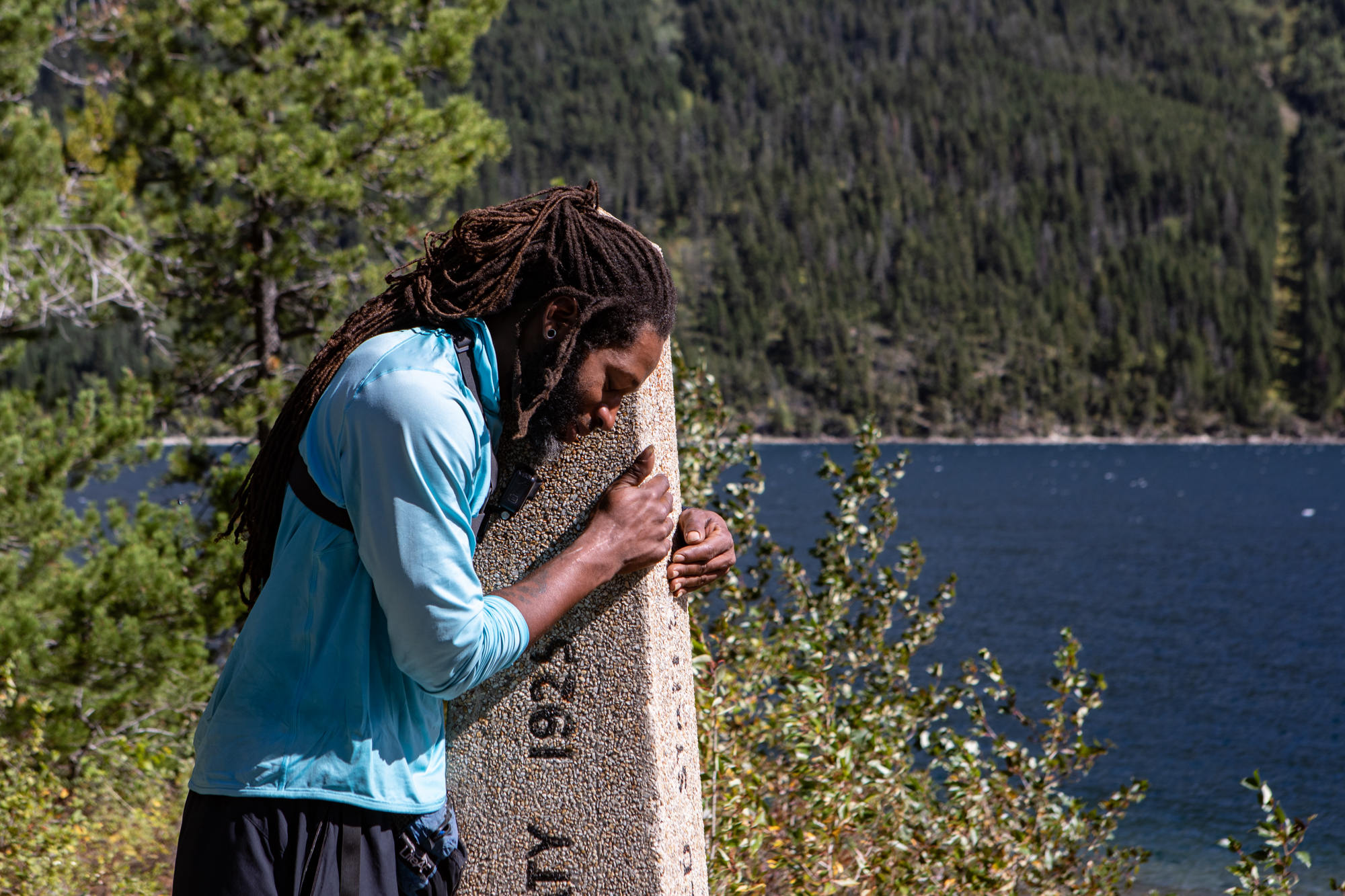 Akuna hugs a pole signifying the US/Canadian border and also the end of the PCT. 