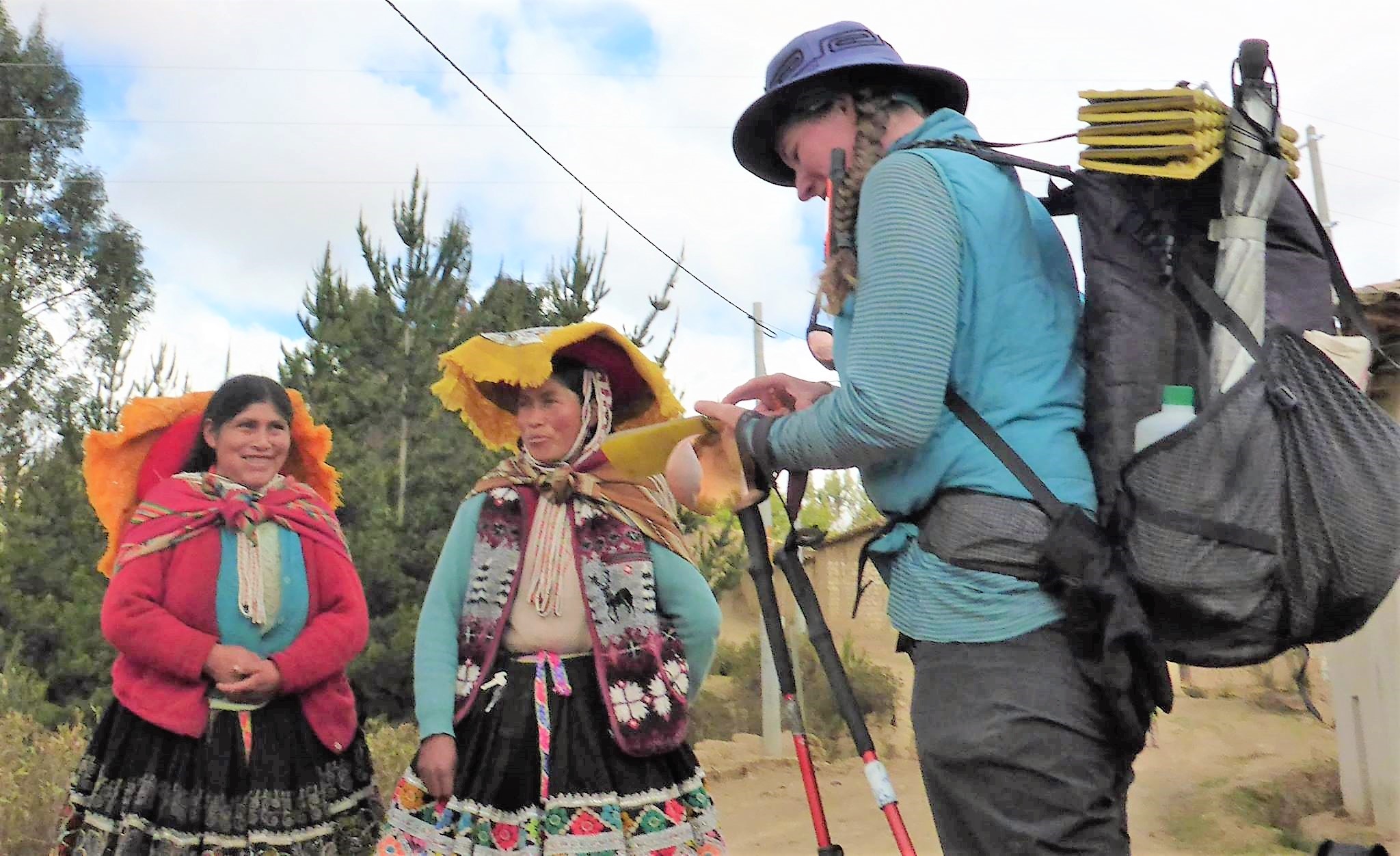 Fidgit, laded down with her backpacking gear, interviews two Quechua women. 