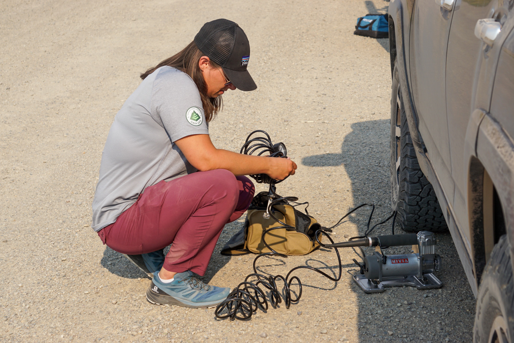 person inflating their tires using a portable air compressor