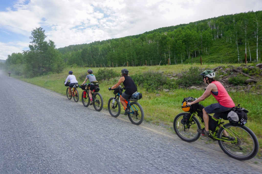 four bikepackers riding a gravel road in Colorado