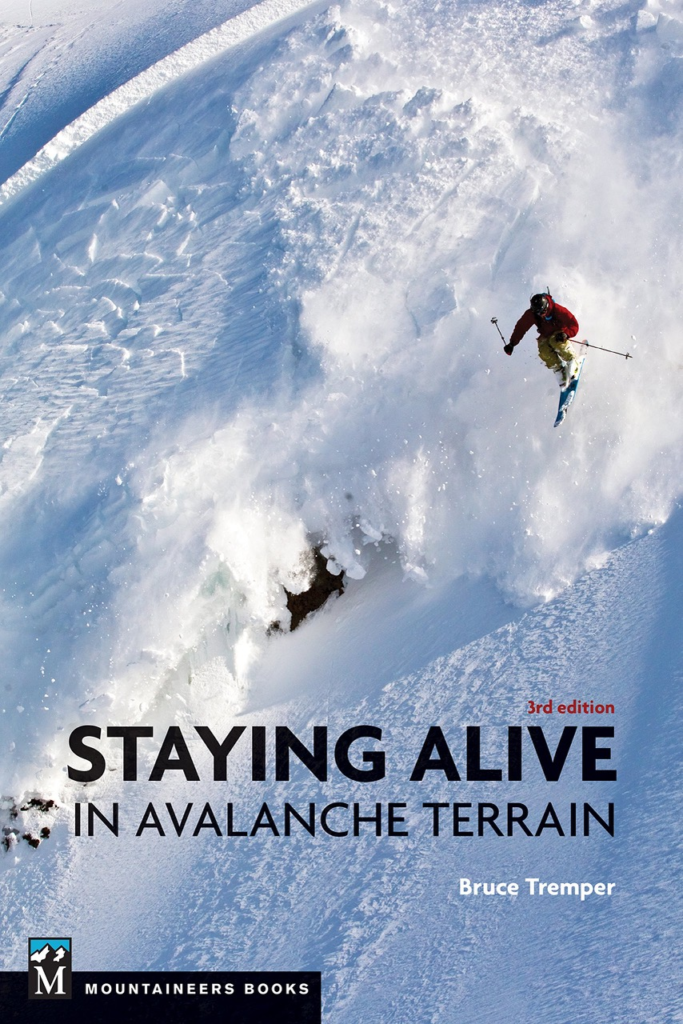 The cover of Tremper's snow safety book Staying Alive in Avalanche Terrain. The cover shows a skier catching air off a cliff in steep terrain.  