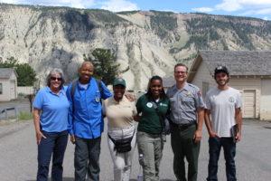 A group of people GYF and NPS employees pose for the camera in front of the big walls of Yosemite.
