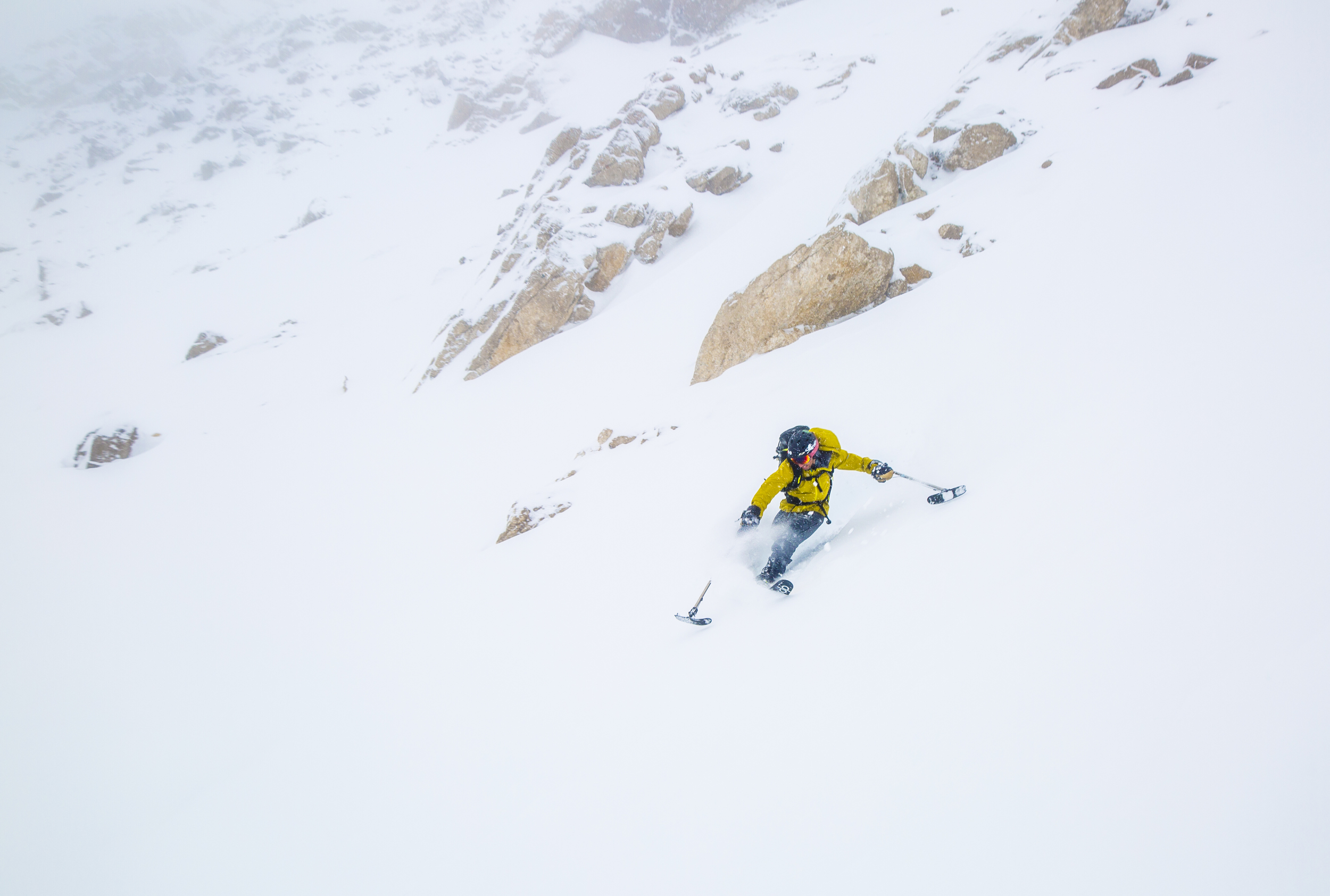 A skier with a leg difference sends it down a mountain. He is using outrigers and one ski. 