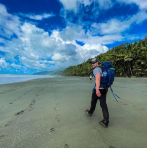 Man with backpack walking along a beach in Costa Rica.
