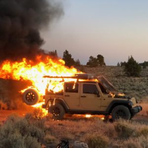 a jeep on fire in the middle of the desert