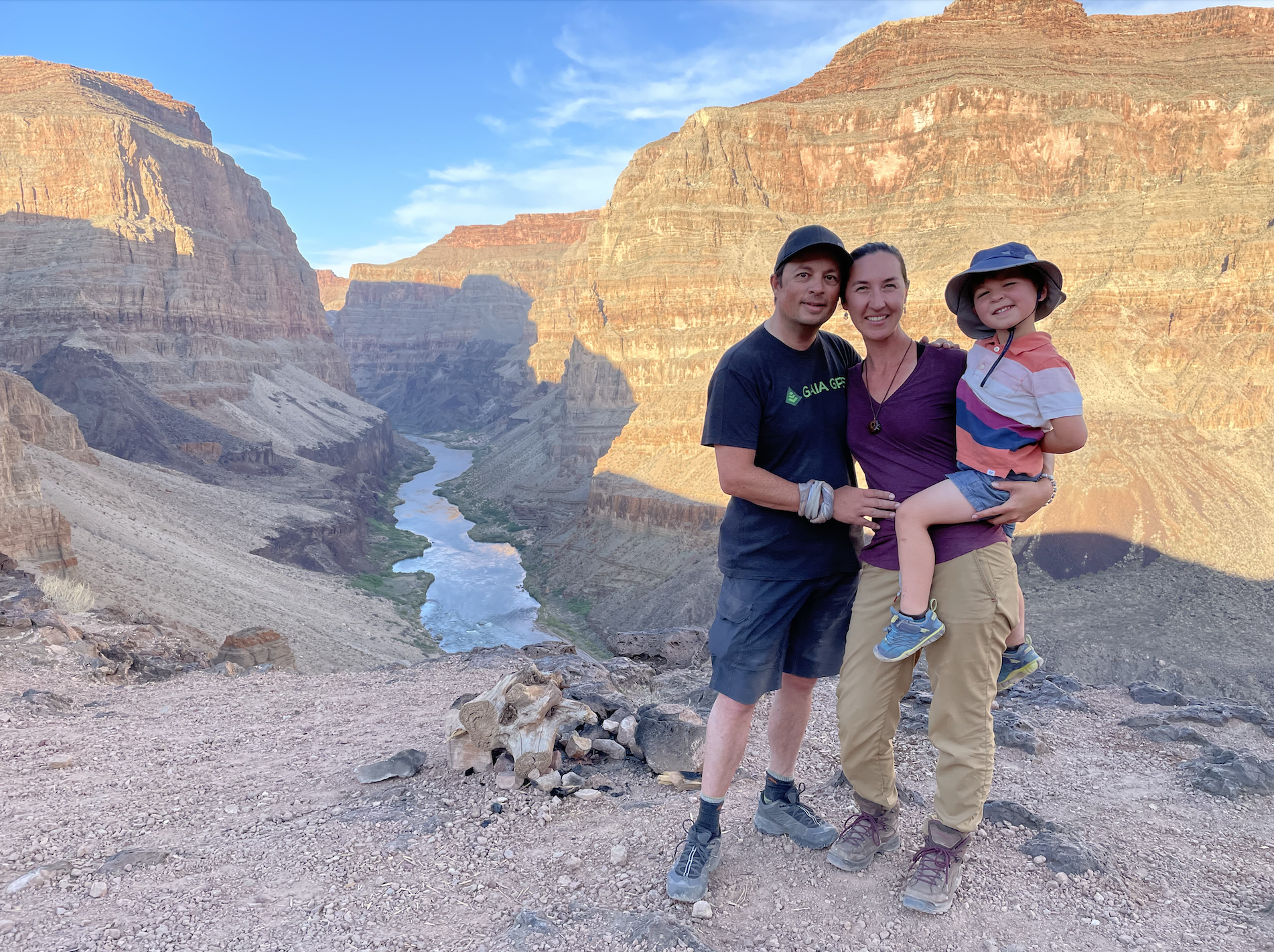 Brittany (holding son) and Eric pose in front of a canyon. 