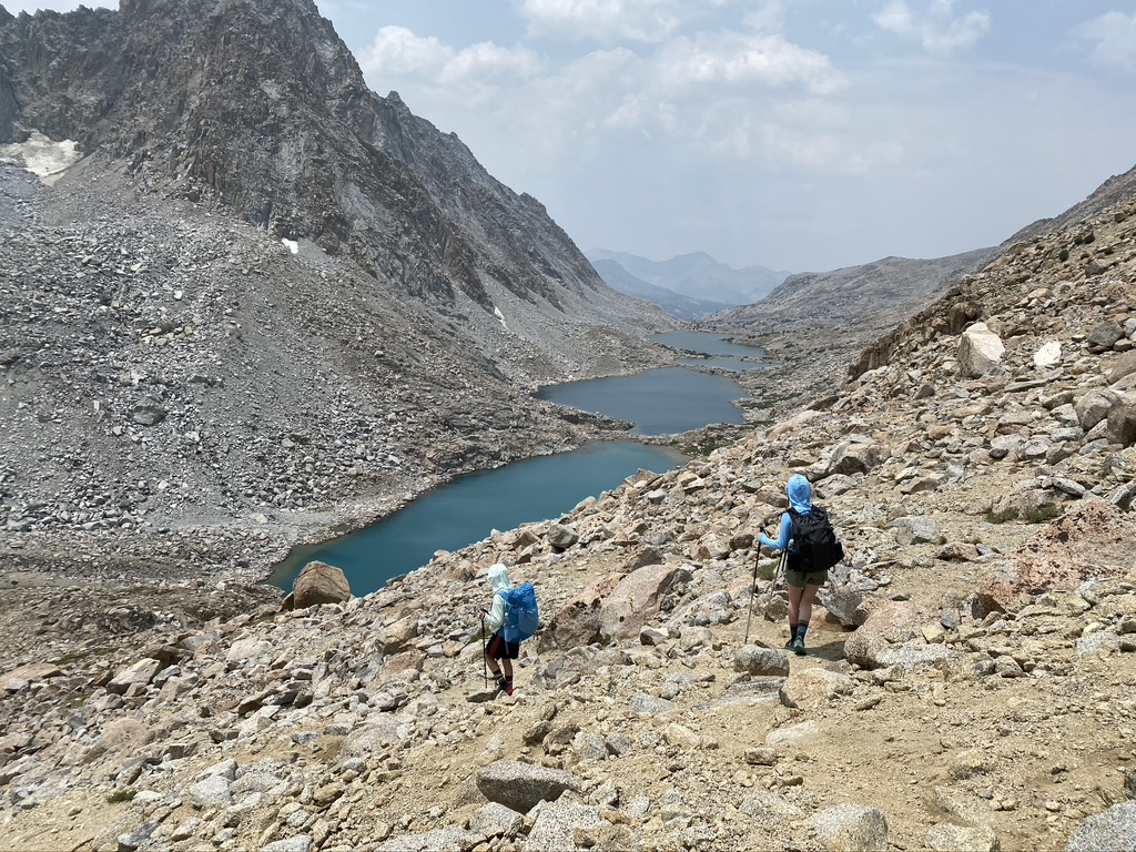 two hikers walking on a mountain side